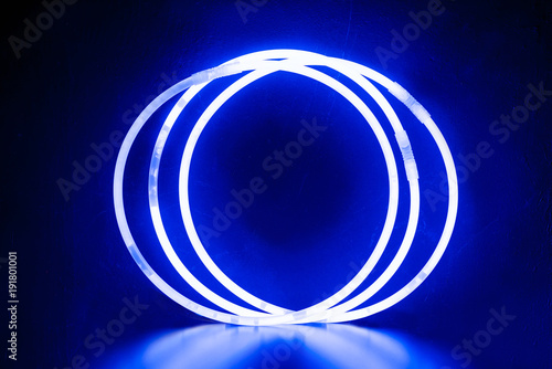 blue round bracelets/ Three round bracelets of glow sticks of blue with neon glow. With reflection on a black background