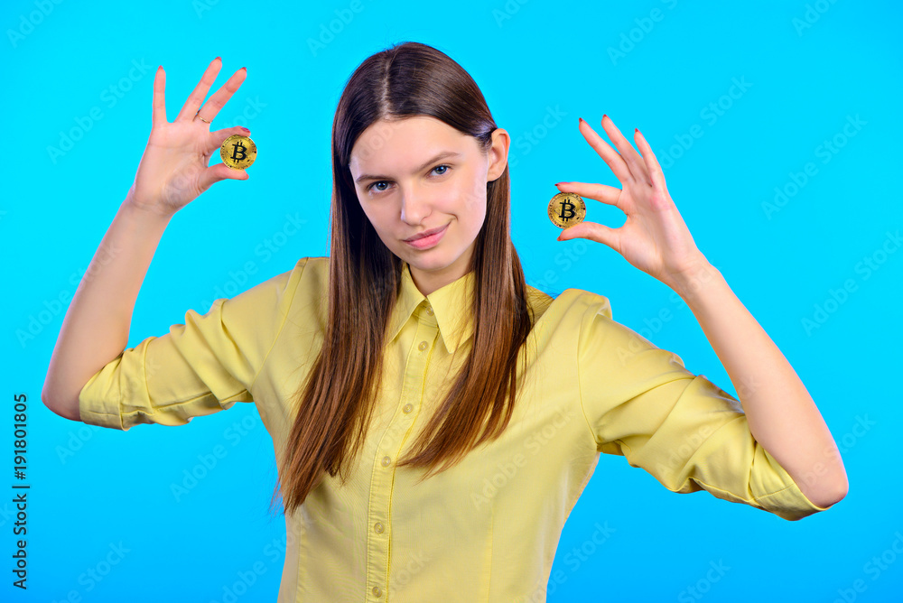 girl in a yellow shirt holds golden bitcoins girl in a yellow shirt holds golden bitcoins