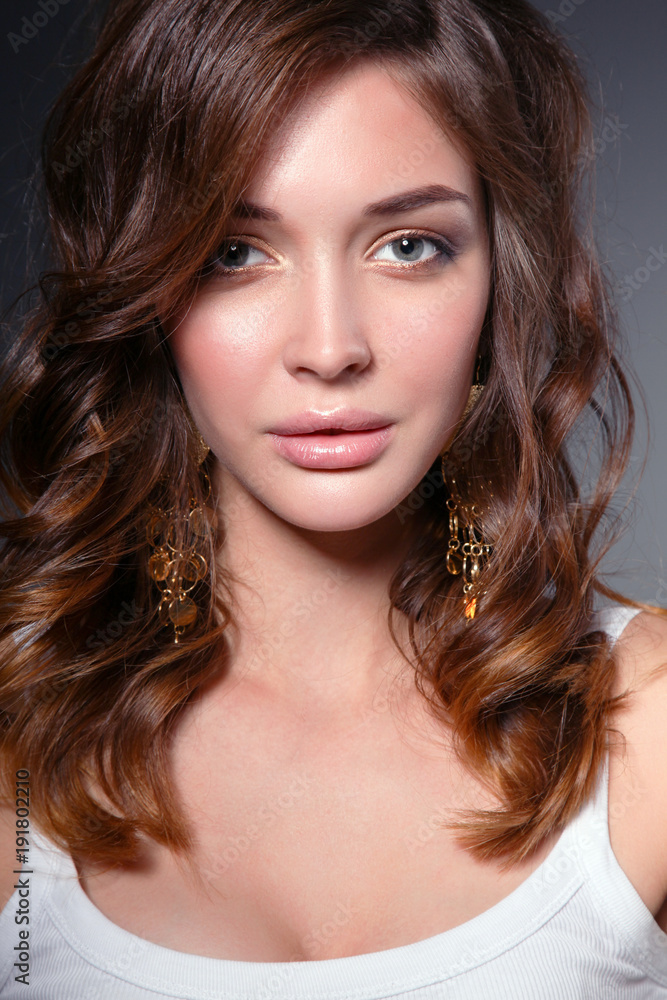 Naklejka premium Portrait of beautiful young woman face. Isolated on dark background.