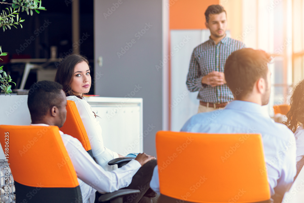 Obraz premium Group of casually dressed businesspeople discussing ideas in the office.