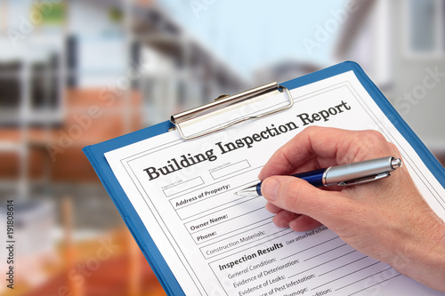Photo Buiding Inspector completing an inspection form on clipboard