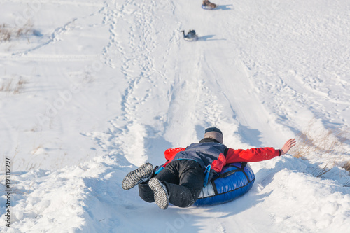 Children ride on tubing. Winter entertainment. Skiing in the winter. Snowy fun in the winter. Fun in the winter. Tubing. photo