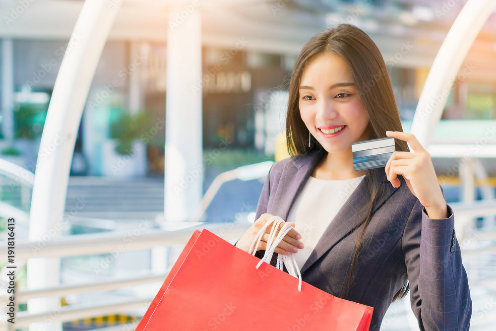 Happy asian business woman showing credit card and hold shopping bags at modern street. concept of purchasing, pre order, buyer, marketing and advertising. Happy asian business woman showing credit card and hold shopping bags at modern street. concept of purchasing, pre order, buyer, marketing and advertising.