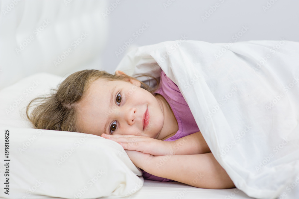 little girl lying on the bed