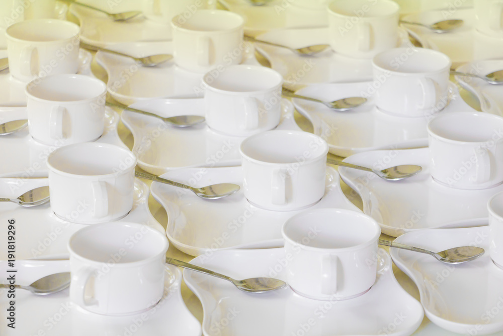 white coffee cup row with saucer and spoon on table white coffee cup row with saucer and spoon on table