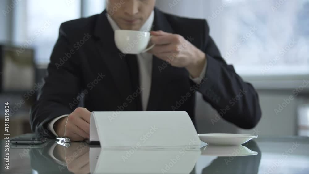 Oligarch drinking coffee in his office and reading text of contract for signing Oligarch drinking coffee in his office and reading text of contract for signing