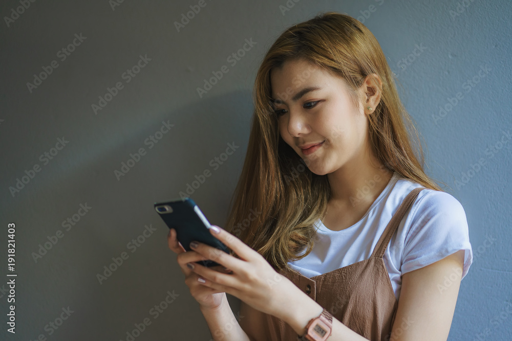Portrait of a smiling casual woman holding smartphone