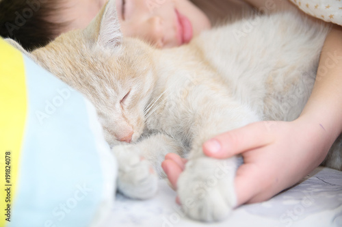 boy sleep with cat, favorite pet lying on child chest,.Interactions between children and Cats