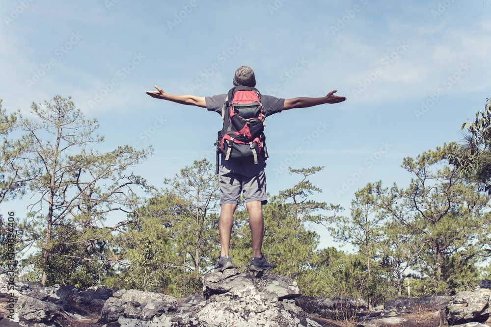 Man with backpack standing on rock