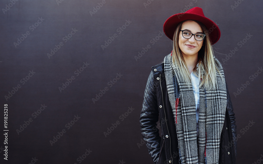 Portrait shoot of young stylish woman with red hat smiling against blue background. Beautiful young woman with copy space. Portrait shoot of young stylish woman with red hat smiling against blue background. Beautiful young woman with copy space.
