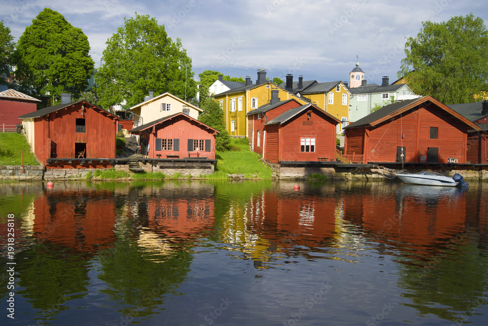 Red old barns on the river bank on a sunny summer day. Old Porvoo, Finland