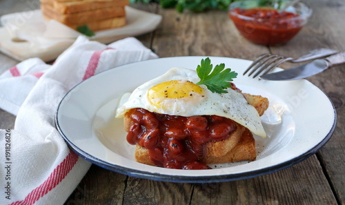 Toast with fried egg and beans on a plate
