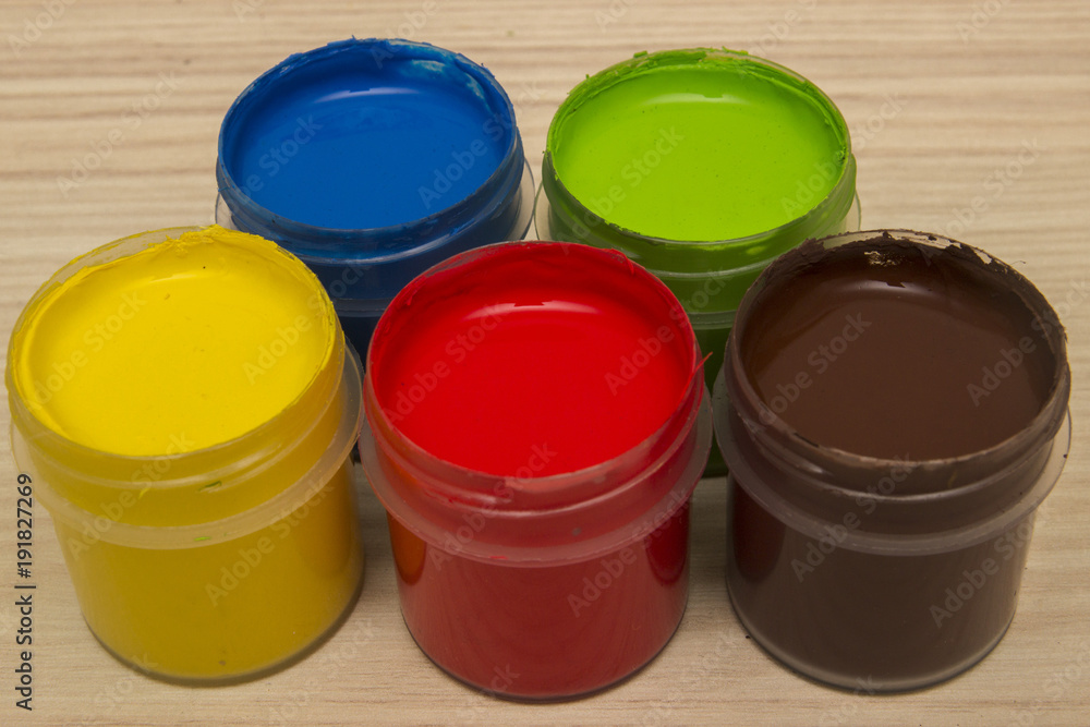 Finger paints in jars on a wooden background Finger paints in jars on a wooden background