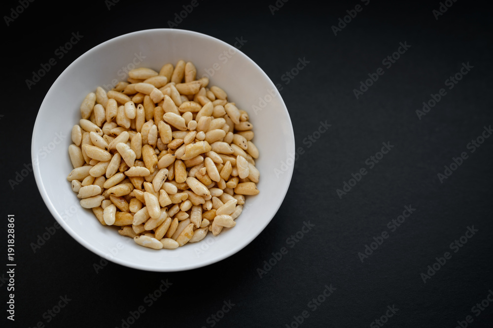 Puffed rice in white cup on dark background. Puffed rice in white cup on dark background.