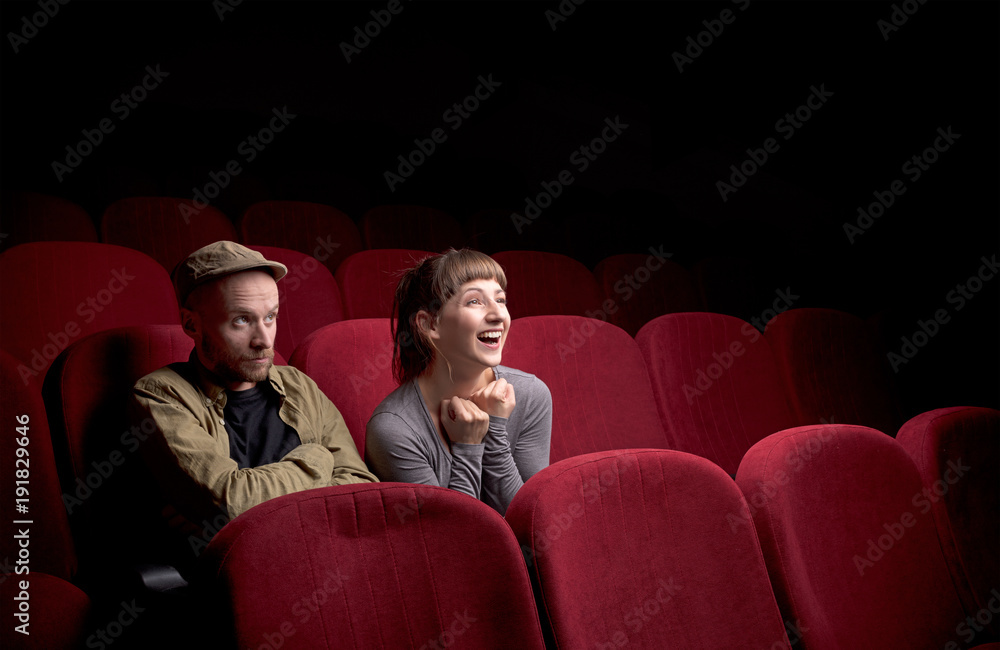 Naklejka premium Young couple sitting at red movie theatre