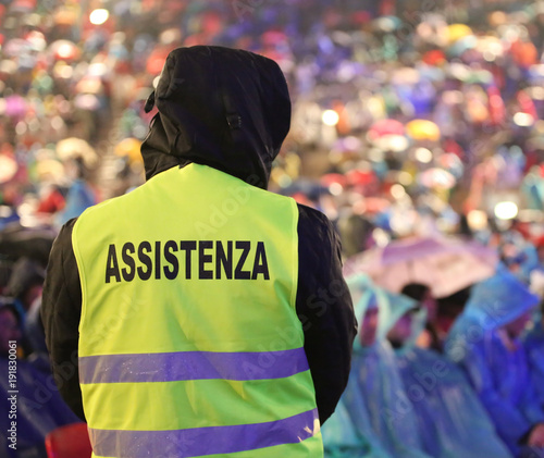 security guard during the event with text ASSISTENZA that means Assitance in Italian language and many people while raining © ChiccoDodiFC