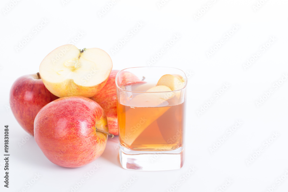 Apple cider vinegar in a glass cup and fresh apples on white background. Apple cider vinegar in a glass cup and fresh apples on white background.