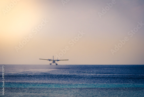 Private seaplane taking off in the ocean lagoon.