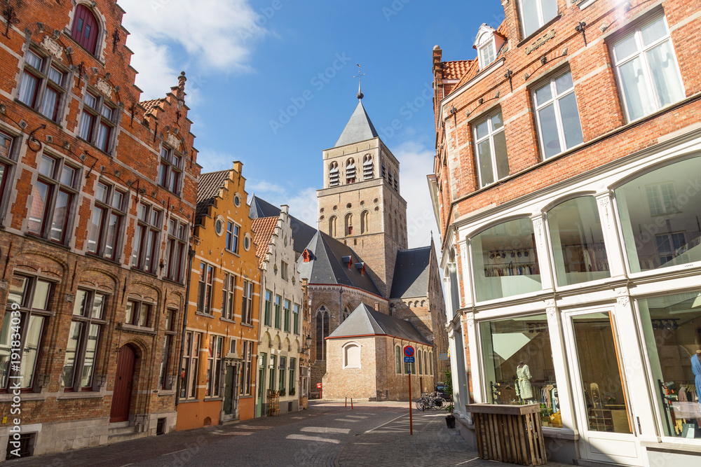 Typical street with medieval Flemish architecture of Bruges, Belgium. Red brick houses and towers. Sint Jacobskerk church in sight.