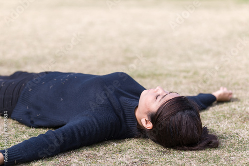 芝生に寝転ぶ女性 © imacoconut