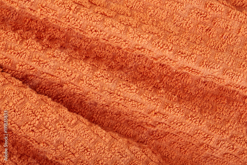 orange fabric and texture concept - close up of a towel terry cloth or terry textile background