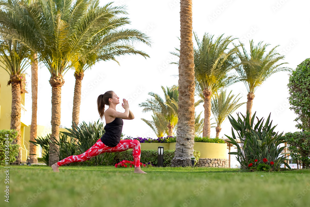 Slender girl does yoga exercises in the early morning at the resort. Healthy lifestyle.