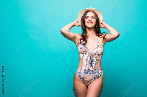 Attractive woman with pink swimwear and straw hat isolated on a green background © F8  \ Suport Ukraine