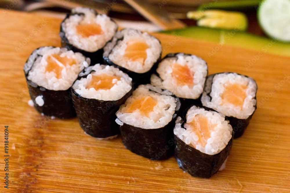 Preparation of Japanese rolls from salmon. Rolls on a wooden board Preparation of Japanese rolls from salmon. Rolls on a wooden board