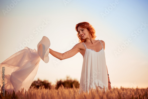 Beautiful lady in wheat field at sunset.