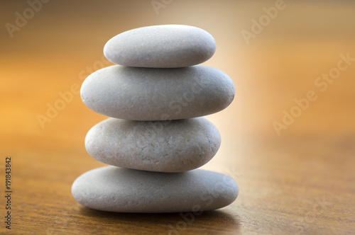 Stone cairn tower  poise stones  rock zen sculpture  light white pebbles on wooden background