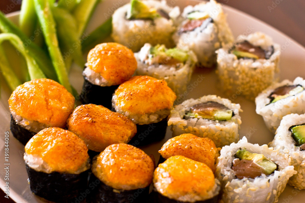 Japanese hot sushi and rolls with salmon, avocado, cucumber and flying fish caviar Japanese hot sushi and rolls with salmon, avocado, cucumber and flying fish caviar
