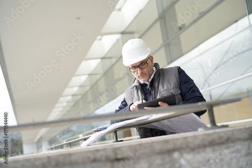 Engineer on site checking project on digital tablet