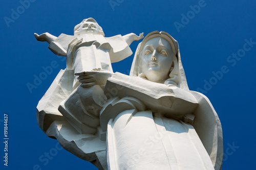  Giant statue of the Virgin Mary with Jesus in his arms against a blue sky close-up in Vung Tau.
