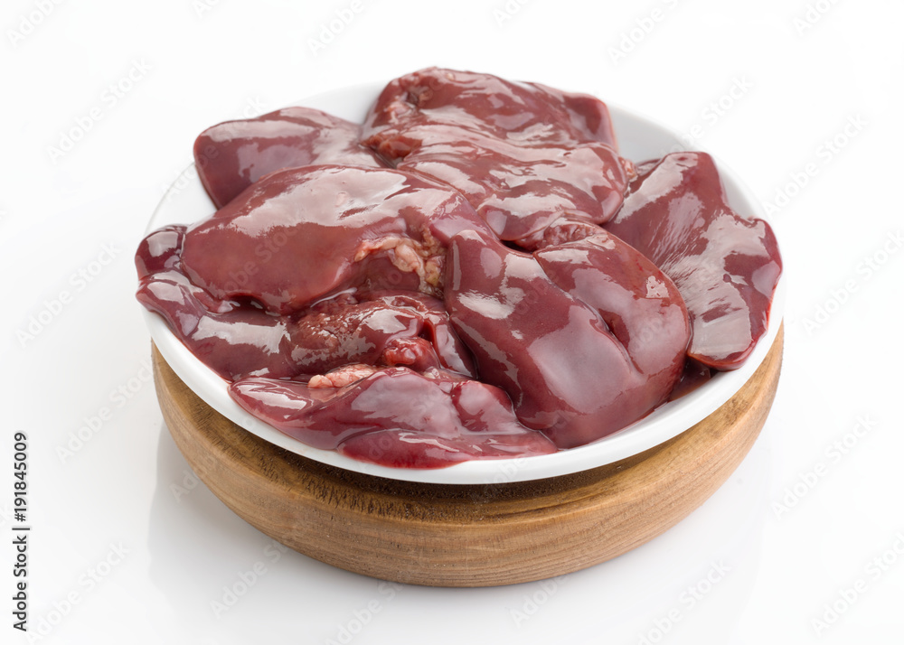 raw chicken liver in white plate on wooden board