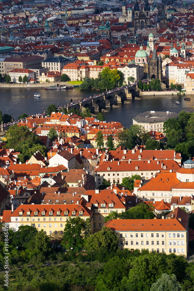 Tourists walk on the famous historic Charles Bridge over Vltava River in Prague, Czech Republic