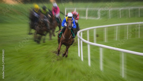 Galloping racehorse in the lead on the track turn,zoom motion blur effect © Gabriel Cassan