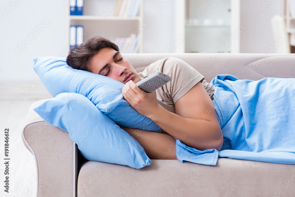 Man watching tv from bed holding remote control unit Man watching tv from bed holding remote control unit