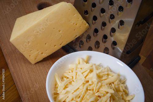 Grated Dutch cheese in a plate on a wooden board