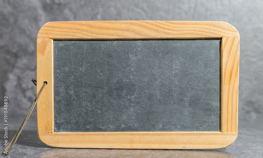 Alte Kreidetafel vor grauem Hintergrund Alte Kreidetafel vor grauem Hintergrund