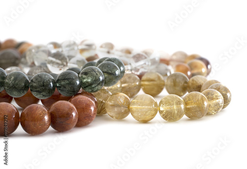 Beautiful translucent assorted colors Rutilated Quartz or Venus’ hairstone bead in bracelets on white background