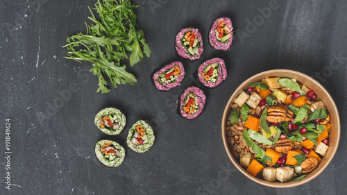 Diet and vegetarian lunch food set - mix salad, spring rolls and granola on dark background. Flat top view, from above. Copy text in center banner.