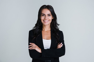 Perfect business lady. Beautiful young businesswoman looking at camera with smile while standing against white background