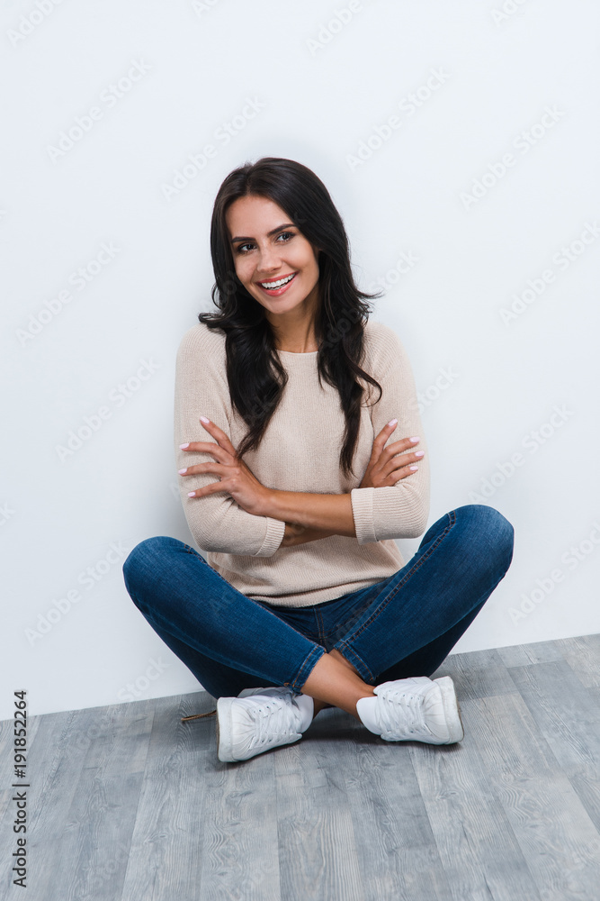 Casual and beautiful. Beautiful young woman looking at camera with smile while flooring against white background Casual and beautiful. Beautiful young woman looking at camera with smile while flooring against white background