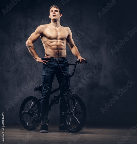 A handsome man with BMX in a studio.