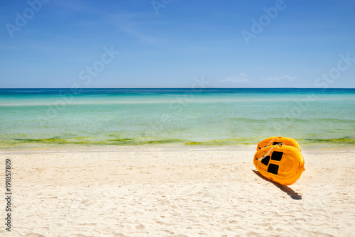 yellow paddle boards and children boats on tropical beach