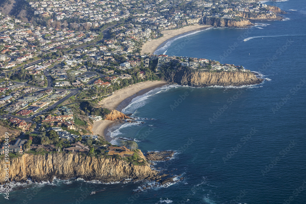Aerial view of affluent homes surrounding scenic coves in Laguna Beach, California.