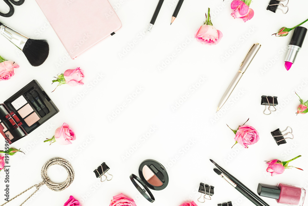 Workspace with cosmetics, accessories and pink roses on white background. Top view. Flat lay