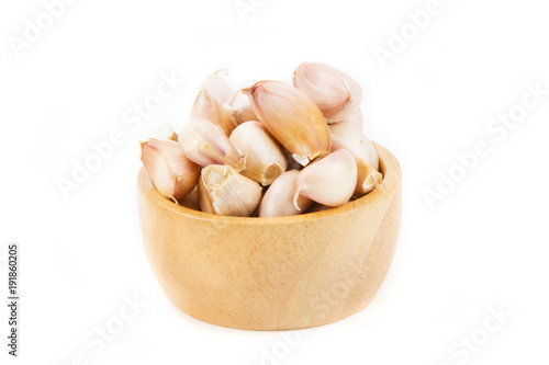 Garlic clove in wood bowl isolated white background