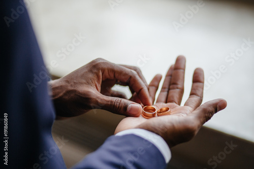 Man's hand holding engagement rings