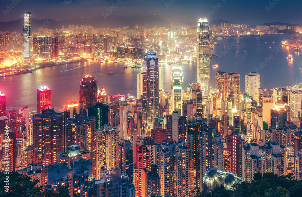 Naklejka premium Malowniczy widok na wyspę Hongkong w Chinach w nocy. Wielobarwna nocna panorama z oświetlonymi drapaczami chmur widziana z Victoria Peak